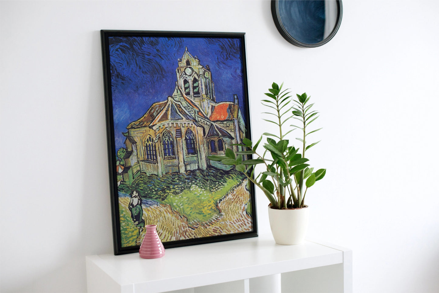 a painting of a church on a wall next to a potted plant