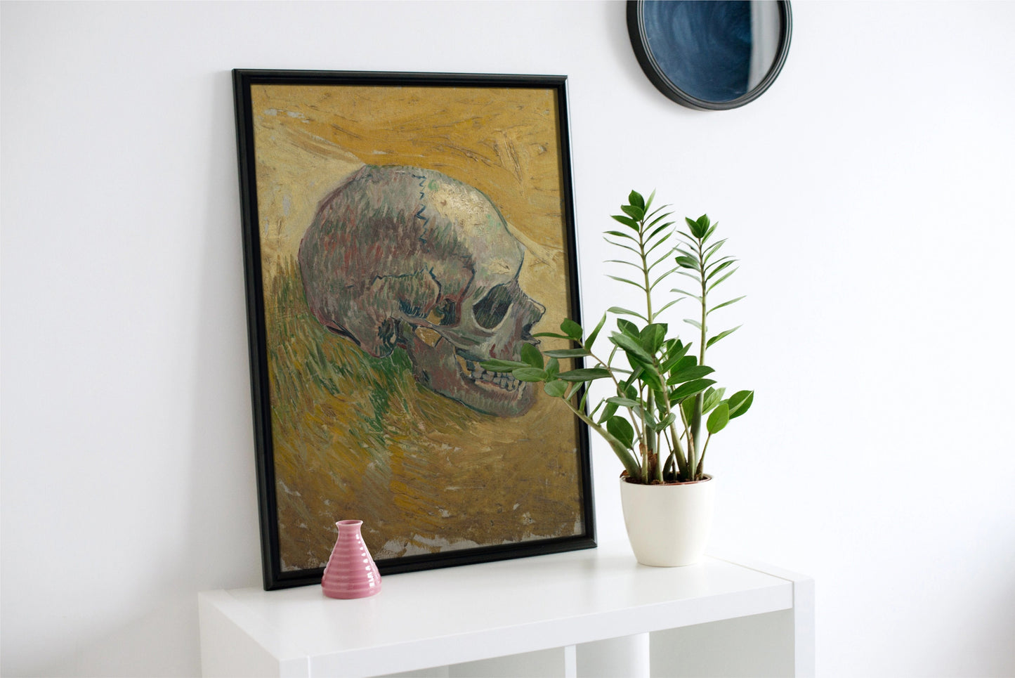 a painting of a skull on a wall next to a potted plant