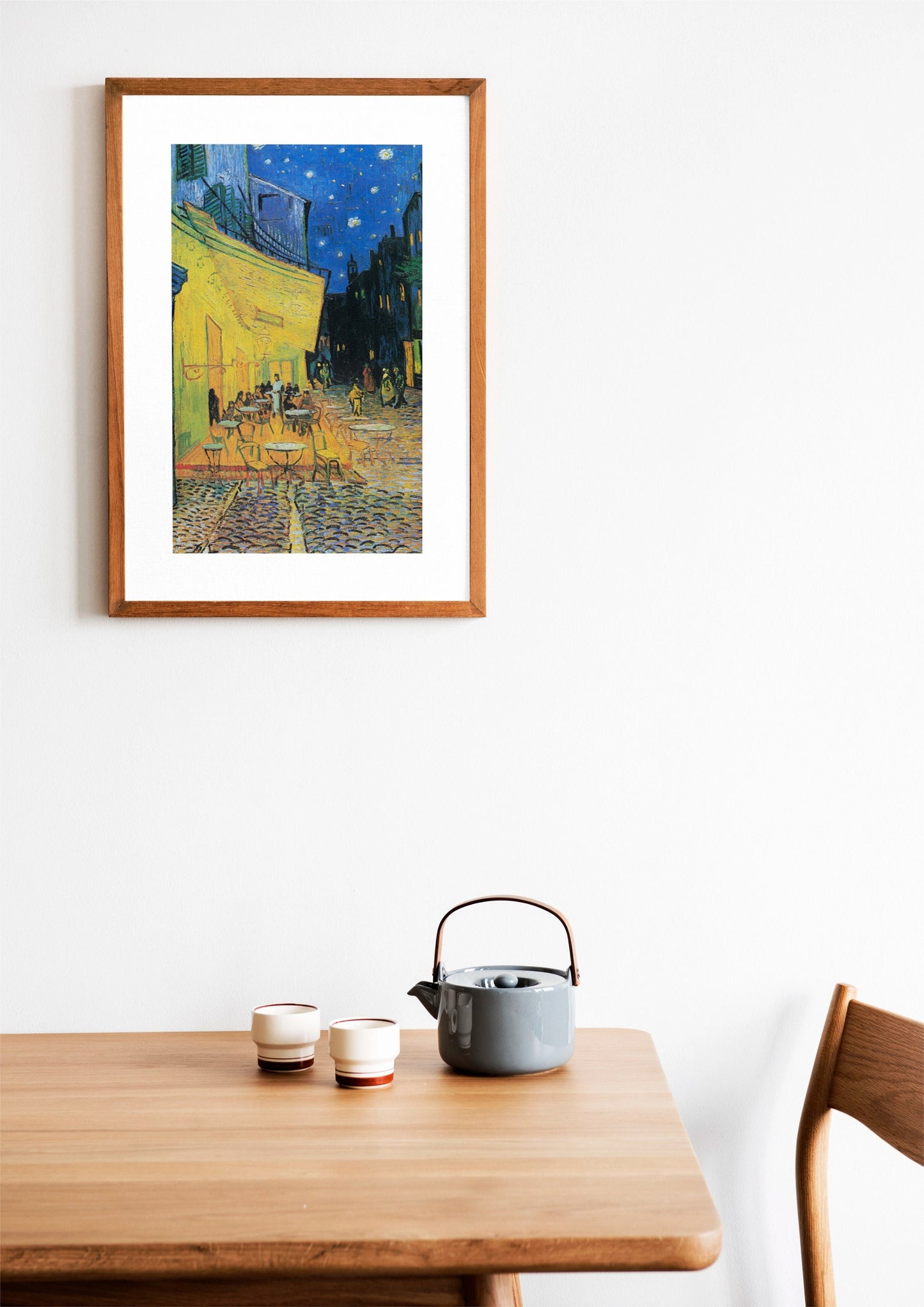 a painting hanging on a wall above a wooden table
