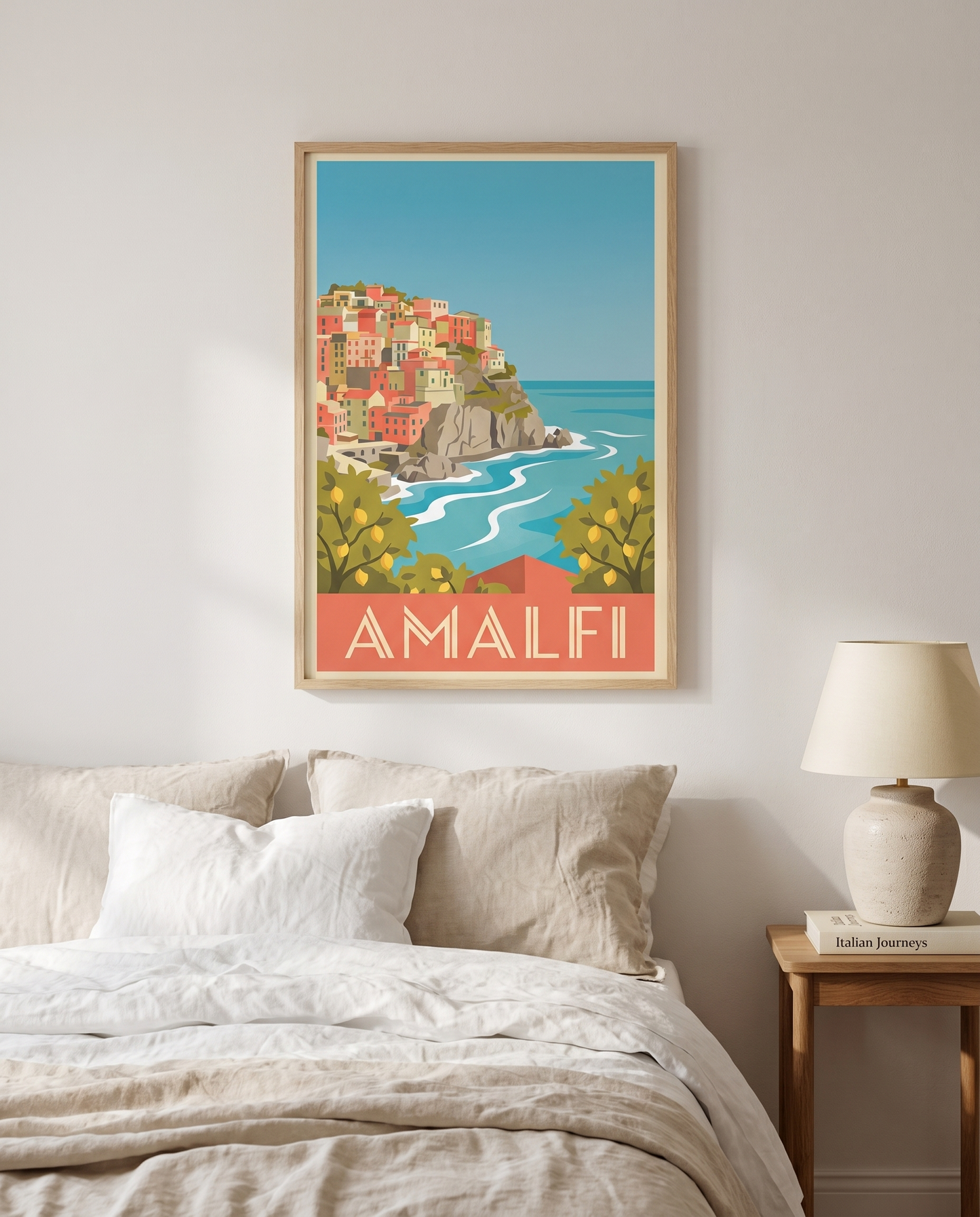 Amalfi travel poster framed in oak above a linen bed