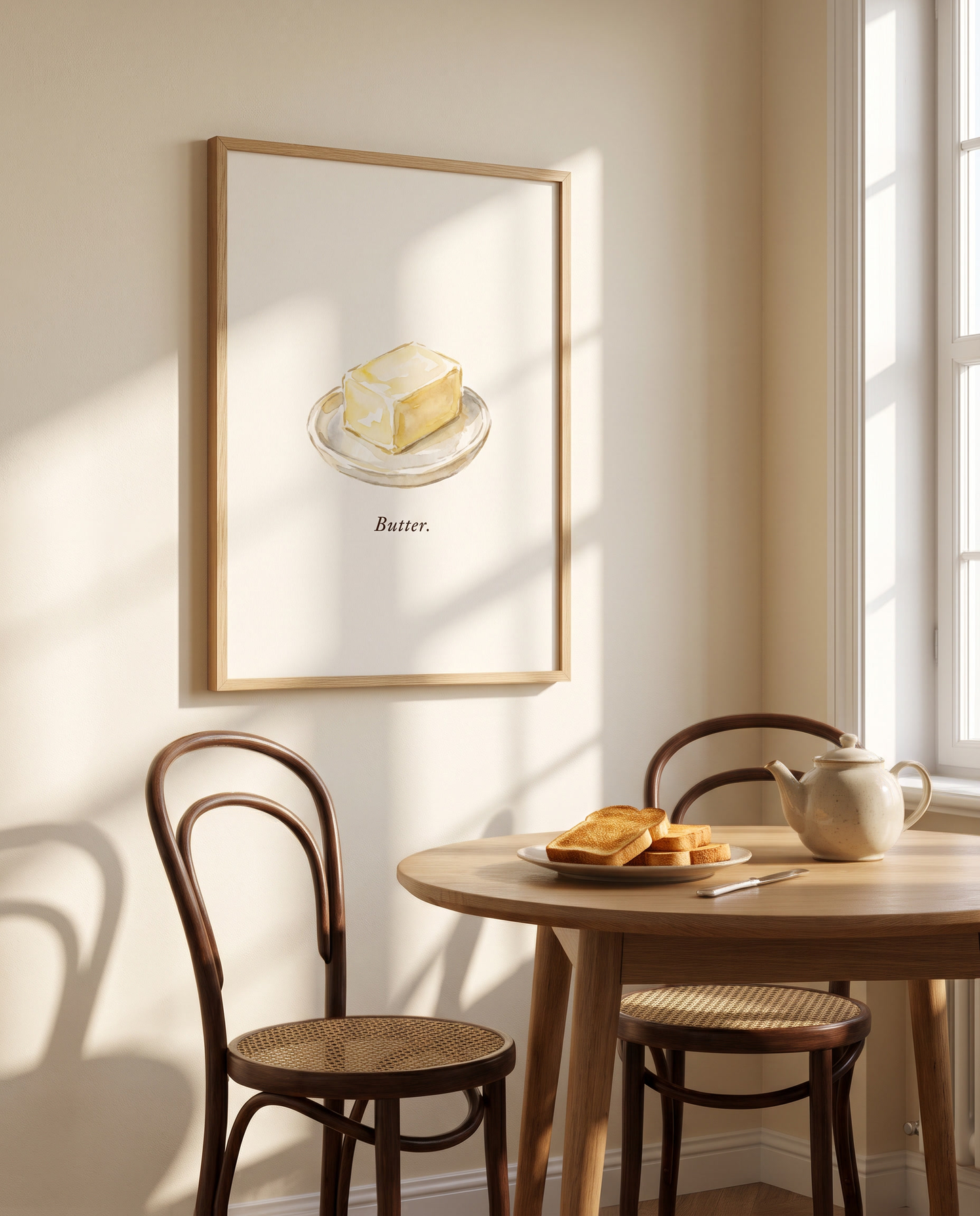 Butter kitchen print framed in oak beside a breakfast nook