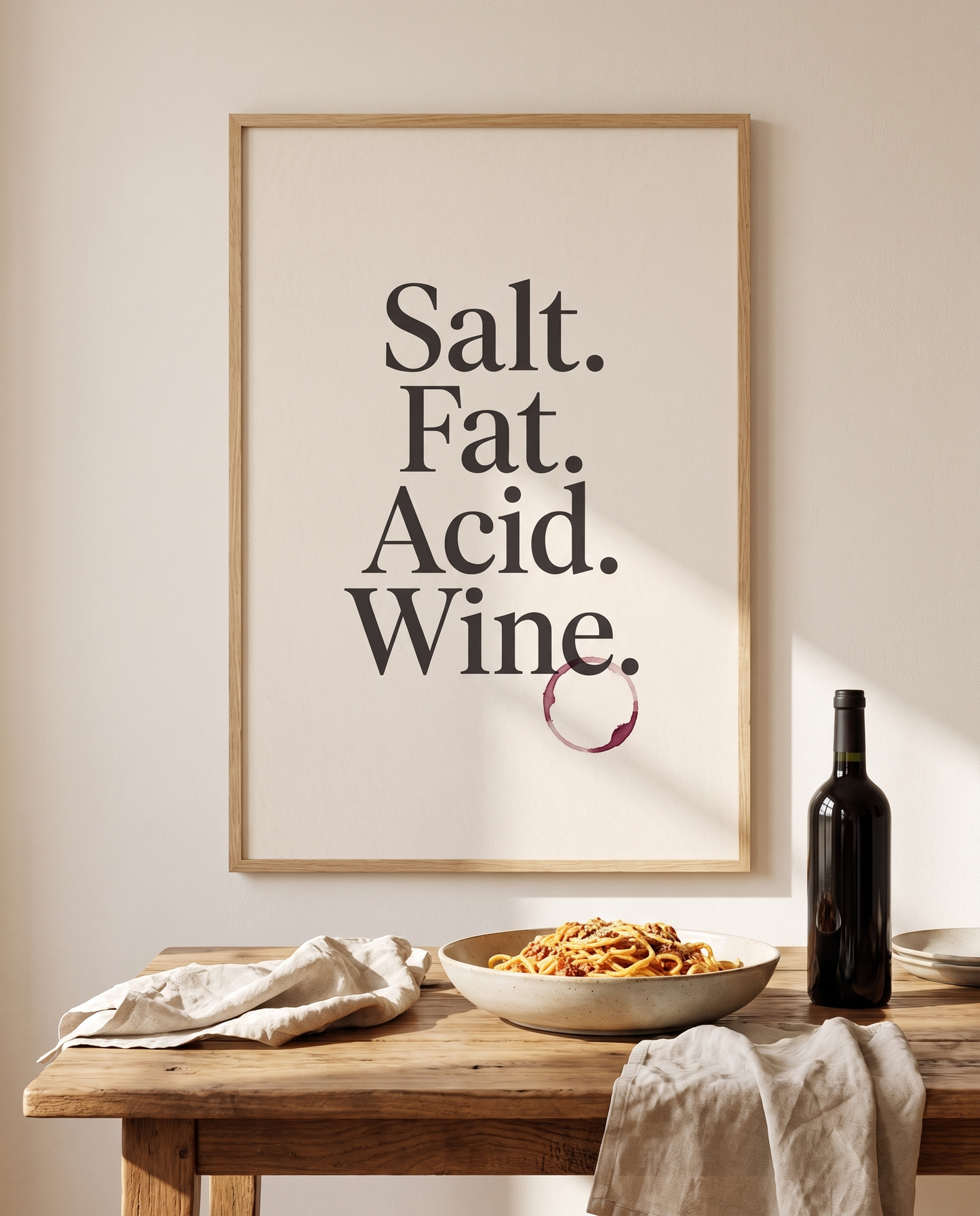 Salt Fat Acid Wine print framed in oak above a dining table